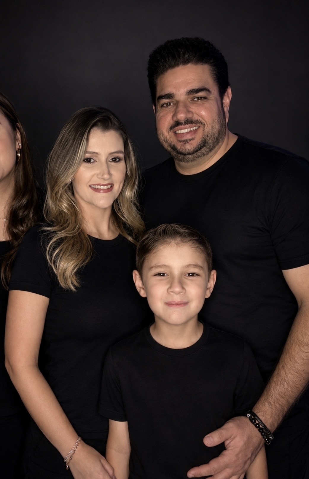 Aldson e Niedja de Paula com a família, retrato em fundo escuro